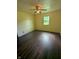 This cozy bedroom features dark wood flooring, a ceiling fan, and a window for natural light at 5043 Harway Ct, Indianapolis, IN 46227