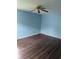 This bedroom features blue walls, wood floors, and a ceiling fan for added comfort at 5043 Harway Ct, Indianapolis, IN 46227
