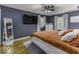 Bedroom with gray walls, hardwood floors, large television and comfy queen bed at 5137 Green Hills Dr, Brownsburg, IN 46112
