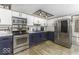 Modern kitchen featuring stainless steel appliances, sleek countertops, and stylish blue and white cabinetry at 5137 Green Hills Dr, Brownsburg, IN 46112