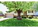 Charming split-level home boasts a lush front yard with mature tree and well-manicured landscaping at 5225 Elderberry Rd, Noblesville, IN 46062