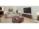 Staged living room featuring a cozy sofa, coffee table, TV, lamps, and an area rug at 5225 Elderberry Rd, Noblesville, IN 46062