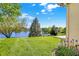 Lush backyard with a pond view and a mix of trees and manicured lawn at 5521 Salem N Dr, Carmel, IN 46033