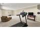 Finished basement with a treadmill, seating, and TV at 5521 Salem N Dr, Carmel, IN 46033
