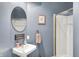 Cozy bathroom featuring a pedestal sink, framed mirror, and a walk-in shower at 5521 Salem N Dr, Carmel, IN 46033