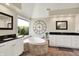 Bright bathroom featuring a soaking tub with tiled surround, dual vanities, and a decorative clock at 5521 Salem N Dr, Carmel, IN 46033