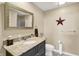 Stylish bathroom with granite counters, a decorative mirror, and a red star on the wall at 5521 Salem N Dr, Carmel, IN 46033