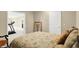 Cozy bedroom featuring a bed with patterned linens and view to an adjacent bonus room with treadmill at 5521 Salem N Dr, Carmel, IN 46033