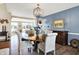 This dining room features elegant table and chairs, with a chandelier and view into the adjacent kitchen area at 5521 Salem N Dr, Carmel, IN 46033