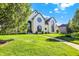 Well-maintained lawn and mature trees accent this house's facade, offering a serene curb appeal at 5521 Salem N Dr, Carmel, IN 46033