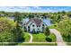 Picturesque home with a circular driveway, lush landscaping, and a serene lakeside setting at 5521 Salem N Dr, Carmel, IN 46033