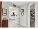 Hallway that opens to a bathroom with white cabinets and a glass door leading to a walk-in closet at 5521 Salem N Dr, Carmel, IN 46033