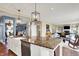 Open kitchen with granite counters, white cabinetry, and views of an adjacent living room offers bright and inviting living at 5521 Salem N Dr, Carmel, IN 46033