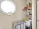 Laundry area with utility sink, storage shelves, and a round window for natural light at 5521 Salem N Dr, Carmel, IN 46033