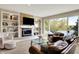 Cozy living room with a fireplace, built-in shelves, and a large window overlooking the lake at 5521 Salem N Dr, Carmel, IN 46033