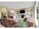 Comfortable living room featuring a fireplace, built-in shelves, and large windows offering outdoor views at 5521 Salem N Dr, Carmel, IN 46033