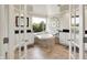 Main bathroom with white cabinets, tiled floors, garden tub, and a large window with a view at 5521 Salem N Dr, Carmel, IN 46033