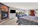 A view of a large main bedroom with a fireplace, TV, sitting area, and a window overlooking the backyard at 5521 Salem N Dr, Carmel, IN 46033