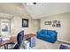 A blue sofa complements a home office with a vaulted ceiling and natural light at 5521 Salem N Dr, Carmel, IN 46033