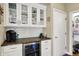 Stylish wet bar featuring glass-front cabinets, granite countertops, and a built-in wine cooler at 5521 Salem N Dr, Carmel, IN 46033
