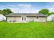 Expansive backyard with well-maintained lawn, patio, shed, and view of the home's exterior at 605 Memorial Dr, Edinburgh, IN 46124