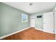 Bedroom showcasing a window, closet, and modern wall-mounted television; features light-green walls and wood-look flooring at 605 Memorial Dr, Edinburgh, IN 46124