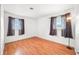 Sunlit bedroom features two bright windows, wood-look flooring, fresh paint, and elegant lamp fixture at 605 Memorial Dr, Edinburgh, IN 46124