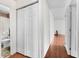 Hallway view with closet, leading to a bathroom and bedroom with wood-look flooring and decor at 605 Memorial Dr, Edinburgh, IN 46124
