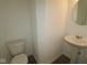 A compact half-bathroom including a traditional-style pedestal sink and toilet against a neutral wall color at 6219 Medina Spirit Dr, Indianapolis, IN 46237