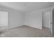 Spacious bedroom with neutral carpeting, two entry doors, and an overhead light at 6219 Medina Spirit Dr, Indianapolis, IN 46237