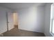 Cozy bedroom featuring plush carpeting, neutral walls, a window for natural light, and an entry door at 6219 Medina Spirit Dr, Indianapolis, IN 46237
