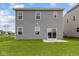 The rear of a gray two-story house boasts a sliding glass door and a well-maintained lawn at 6219 Medina Spirit Dr, Indianapolis, IN 46237