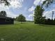 Lush green backyard featuring mature trees, offering a serene and picturesque outdoor setting for relaxation at 7897 Moore Rd, Indianapolis, IN 46278