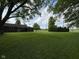 Expansive backyard with lush green grass and mature trees, offering ample space for recreation and relaxation at 7897 Moore Rd, Indianapolis, IN 46278