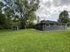 Spacious backyard featuring mature tree, gray siding, a well-maintained lawn and outbuilding at 7897 Moore Rd, Indianapolis, IN 46278