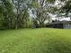 Vast backyard featuring a cozy screened porch and home exterior, set amidst lush green lawns and mature trees at 7897 Moore Rd, Indianapolis, IN 46278