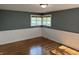 Bedroom with hardwood floors, window, and paneled walls at 7897 Moore Rd, Indianapolis, IN 46278