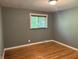 Bedroom featuring hardwood floors, window, and paneled walls at 7897 Moore Rd, Indianapolis, IN 46278