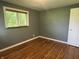 Bedroom featuring hardwood floors, window, and single door at 7897 Moore Rd, Indianapolis, IN 46278