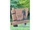 A wooden sign welcomes visitors to Traders Point Rural Historic District with carved farm animal and lush greenery at 7897 Moore Rd, Indianapolis, IN 46278