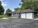 Charming single-story home featuring a two-car garage, gray siding and a walkway leading to the front door at 7897 Moore Rd, Indianapolis, IN 46278