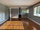 Bright living room with wood-look floors, neutral paint, and a wood-burning stove at 7897 Moore Rd, Indianapolis, IN 46278