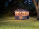 Well-lit shed with screened windows sits serenely on a manicured lawn at dusk at 7897 Moore Rd, Indianapolis, IN 46278