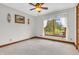 Cozy bedroom with carpet flooring, a ceiling fan, and a window overlooking greenery at 802 Echo Trl, Martinsville, IN 46151