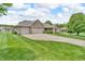 Brick home featuring a two-car garage, manicured lawn, and a mature tree in the front yard at 802 Echo Trl, Martinsville, IN 46151