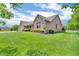 Brick home with a manicured front lawn and a covered porch, set against a blue sky with fluffy clouds at 802 Echo Trl, Martinsville, IN 46151
