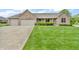 Charming brick home featuring an attached two-car garage and a well-manicured front lawn at 802 Echo Trl, Martinsville, IN 46151