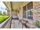 Inviting brick porch with a porch swing, bench seating, and natural light at 802 Echo Trl, Martinsville, IN 46151