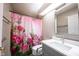 Bathroom featuring pink floral shower curtain, gray cabinets and white countertops at 8066 Cardinal Cove E Dr, Indianapolis, IN 46256
