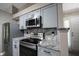 This kitchen features stainless steel appliances, gray cabinets, and granite countertops at 8066 Cardinal Cove E Dr, Indianapolis, IN 46256